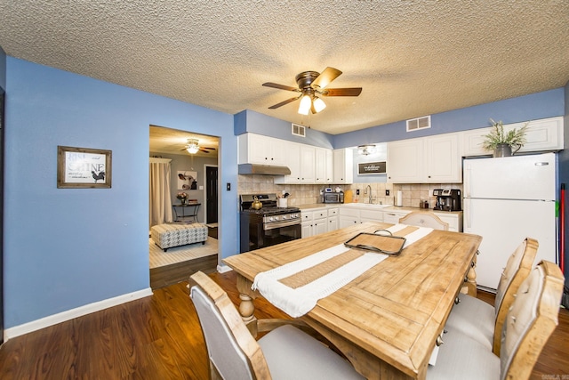 dining space with dark hardwood / wood-style flooring, sink, a textured ceiling, and ceiling fan