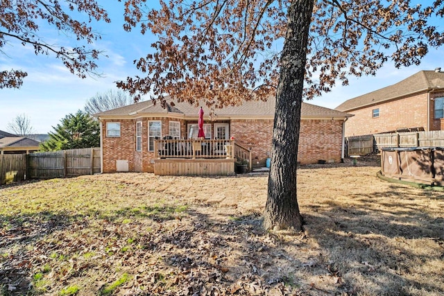 back of property with a swimming pool side deck and a lawn