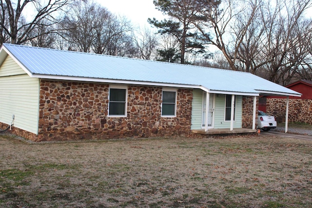 ranch-style house featuring a carport and a front lawn