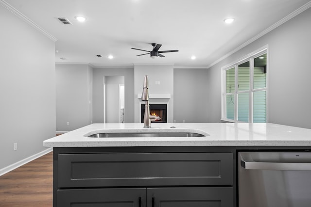 kitchen featuring a center island with sink, crown molding, sink, and stainless steel dishwasher