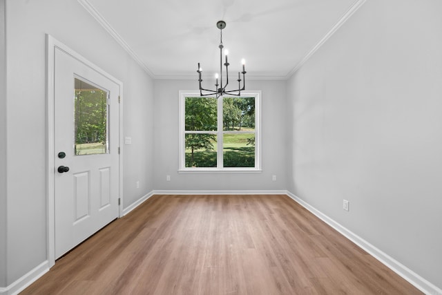 unfurnished dining area with an inviting chandelier, light hardwood / wood-style flooring, and ornamental molding