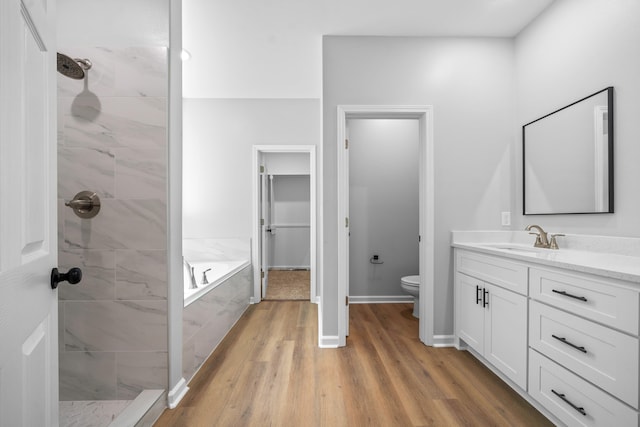 full bathroom featuring vanity, toilet, separate shower and tub, and hardwood / wood-style floors