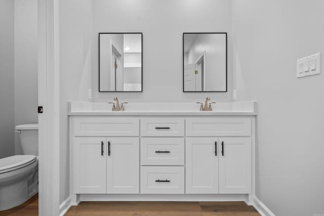 bathroom featuring vanity, hardwood / wood-style floors, and toilet