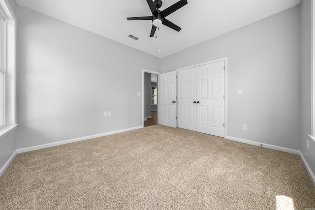 unfurnished bedroom featuring ceiling fan, a closet, and carpet