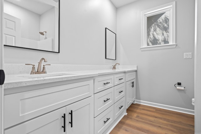 bathroom featuring vanity, hardwood / wood-style floors, walk in shower, and toilet