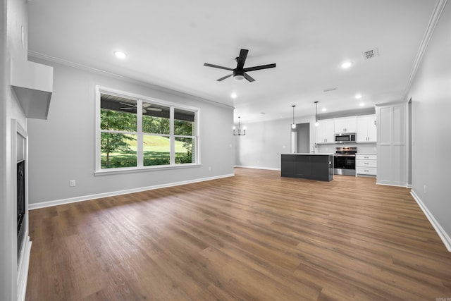 unfurnished living room with ornamental molding, dark hardwood / wood-style flooring, and ceiling fan with notable chandelier