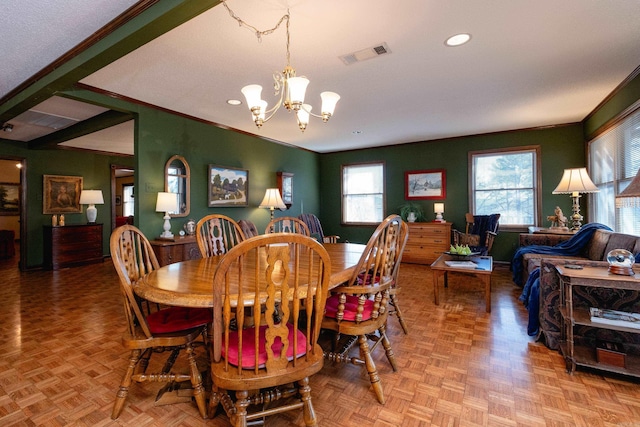 dining room featuring ornamental molding, a chandelier, and light parquet floors