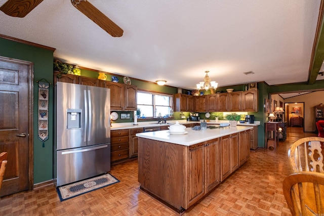 kitchen with light parquet flooring, a kitchen island, pendant lighting, and stainless steel fridge