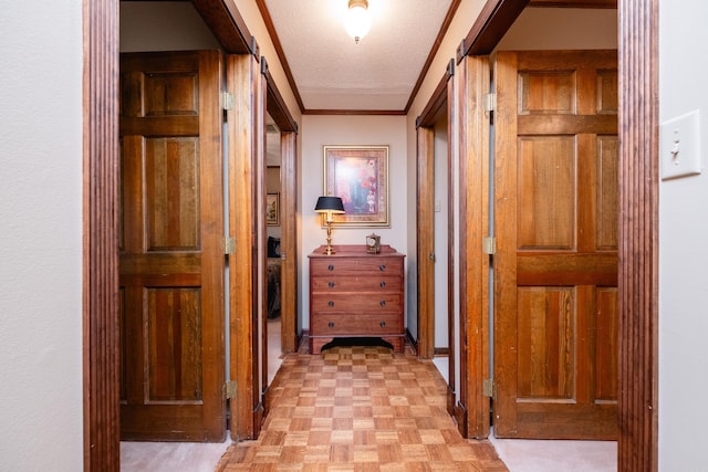 hallway with light parquet floors, ornamental molding, and a textured ceiling