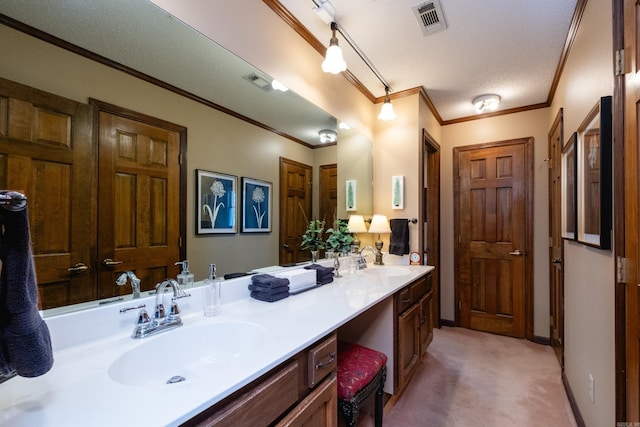 bathroom featuring vanity, ornamental molding, and a textured ceiling