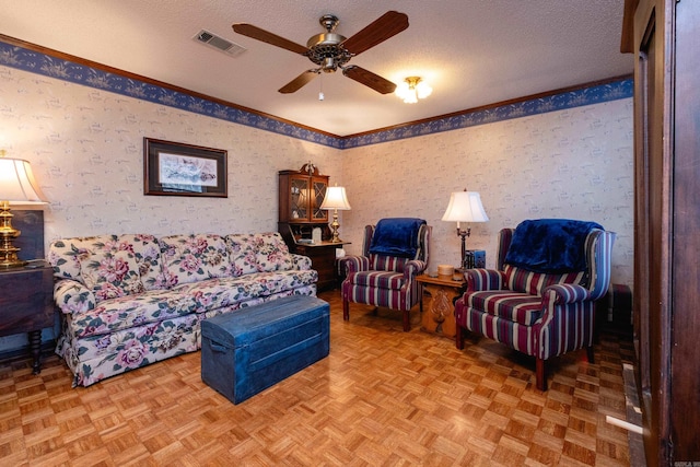 living room with crown molding, ceiling fan, light parquet floors, and a textured ceiling