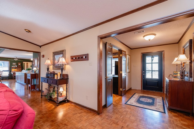 entrance foyer featuring parquet floors, a wealth of natural light, ornamental molding, and a textured ceiling