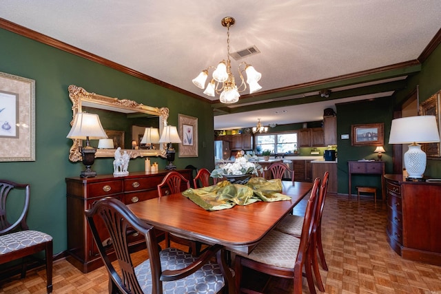 dining room featuring light parquet flooring, crown molding, and an inviting chandelier