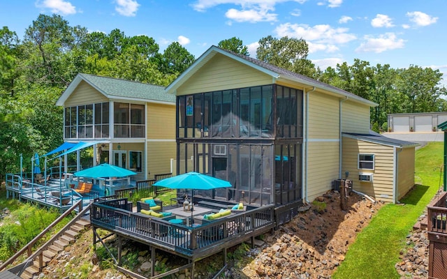 rear view of property featuring a wooden deck and a sunroom