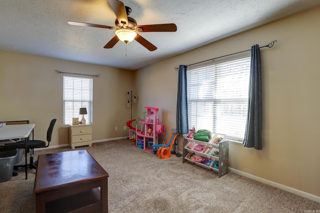 rec room featuring ceiling fan, a textured ceiling, and carpet