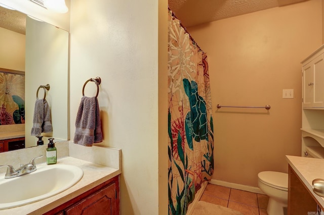 bathroom with tile patterned flooring, vanity, and a textured ceiling
