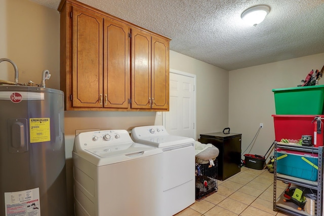 washroom with washer and dryer, water heater, cabinets, light tile patterned floors, and a textured ceiling