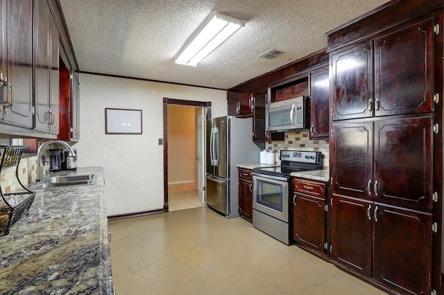 kitchen with appliances with stainless steel finishes, sink, decorative backsplash, light stone counters, and a textured ceiling