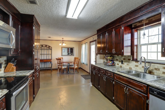 kitchen with pendant lighting, sink, appliances with stainless steel finishes, a textured ceiling, and decorative backsplash
