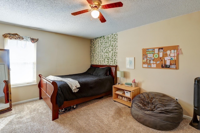 bedroom with ceiling fan, light carpet, and a textured ceiling