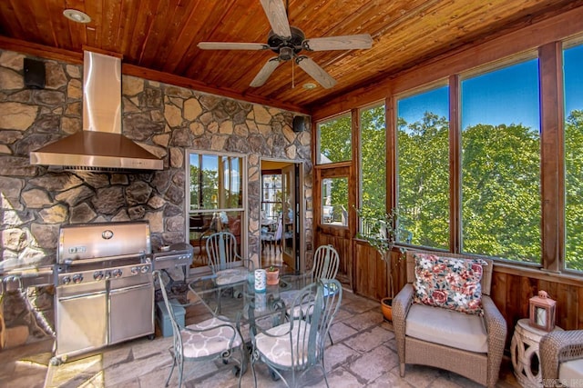 sunroom / solarium with wood ceiling, a wealth of natural light, and ceiling fan