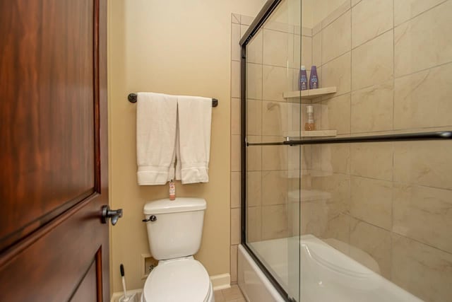 bathroom featuring enclosed tub / shower combo and toilet