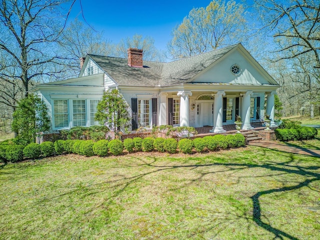 greek revival house with covered porch and a front lawn