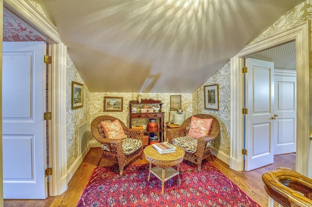 living area with vaulted ceiling and light hardwood / wood-style flooring