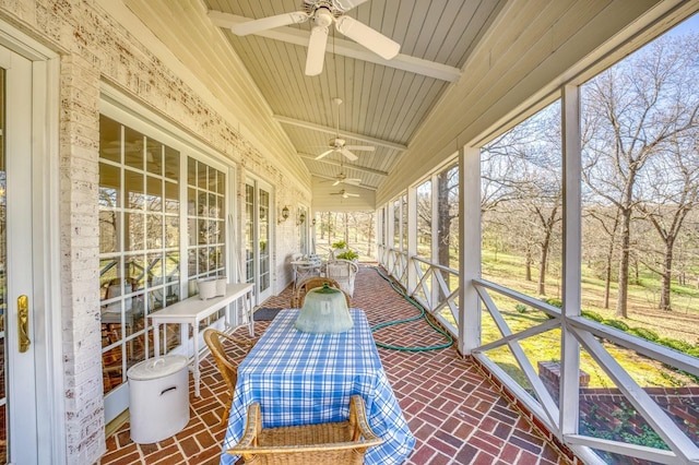 sunroom with lofted ceiling, wooden ceiling, and ceiling fan