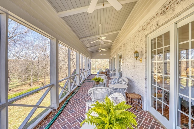 unfurnished sunroom featuring wood ceiling, lofted ceiling with beams, and ceiling fan