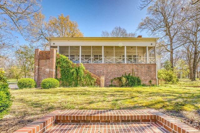 view of front of property featuring a sunroom and a front lawn