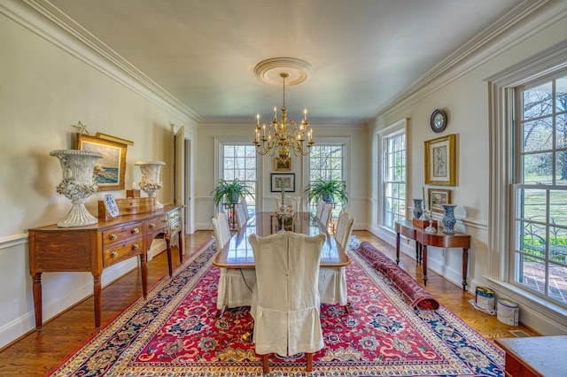 dining area featuring ornamental molding, hardwood / wood-style floors, and a notable chandelier