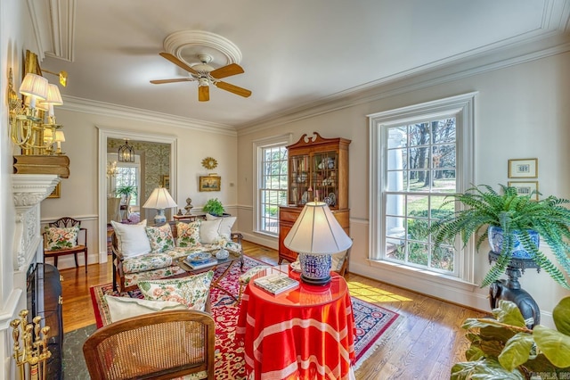 sitting room featuring hardwood / wood-style floors, ornamental molding, and ceiling fan