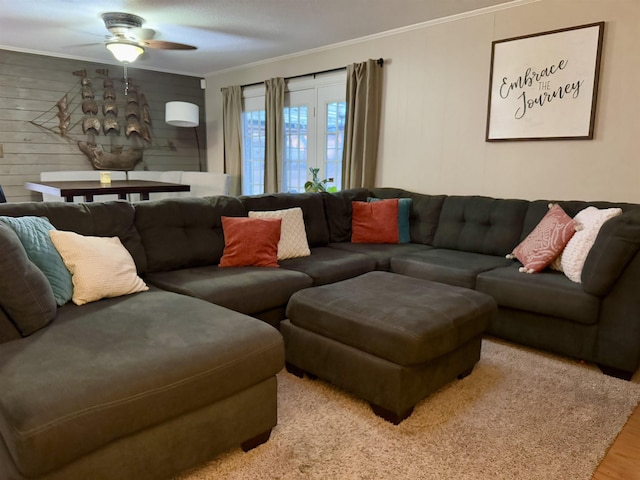 living room with light hardwood / wood-style flooring, ornamental molding, and ceiling fan