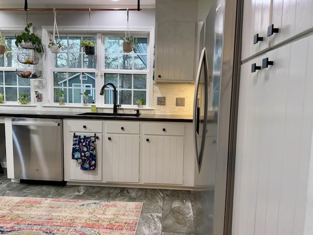 kitchen featuring white cabinetry, appliances with stainless steel finishes, sink, and decorative backsplash