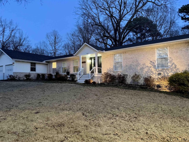 ranch-style house with a porch, a garage, and a front lawn