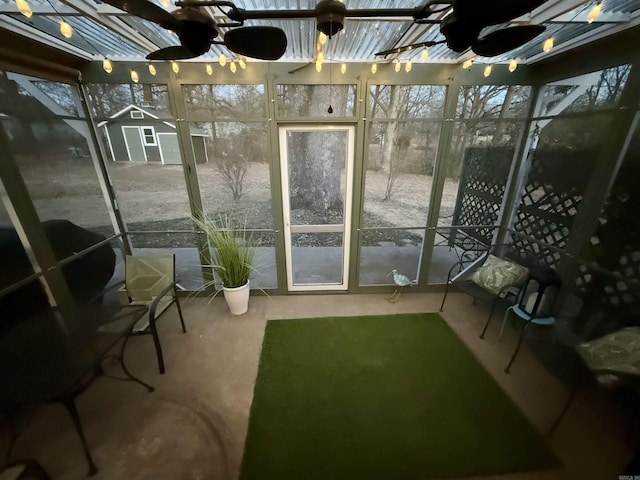 unfurnished sunroom with ceiling fan