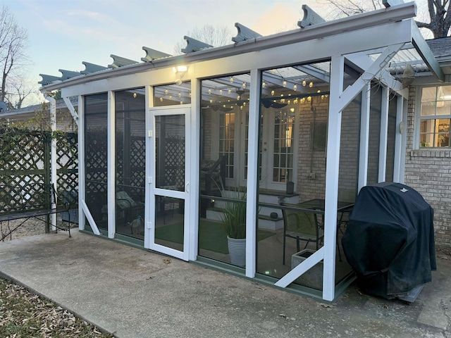 patio terrace at dusk with a sunroom and grilling area