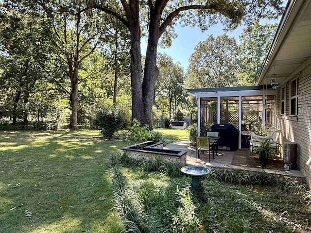 view of yard with a sunroom and a patio area