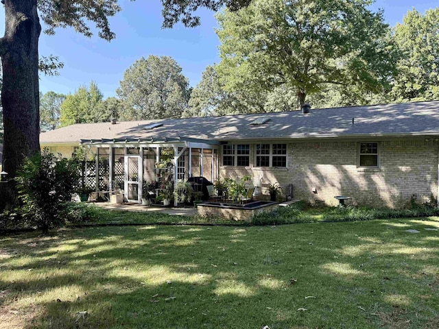 back of property featuring a patio, a sunroom, and a yard