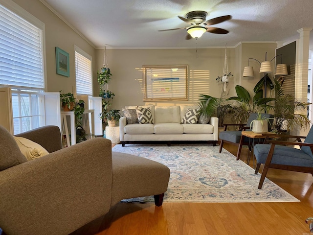 living room with crown molding, hardwood / wood-style flooring, and ceiling fan