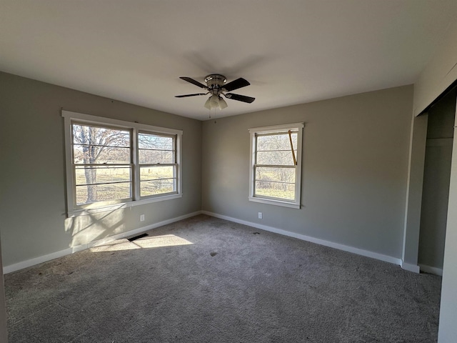 spare room featuring carpet floors, plenty of natural light, and ceiling fan