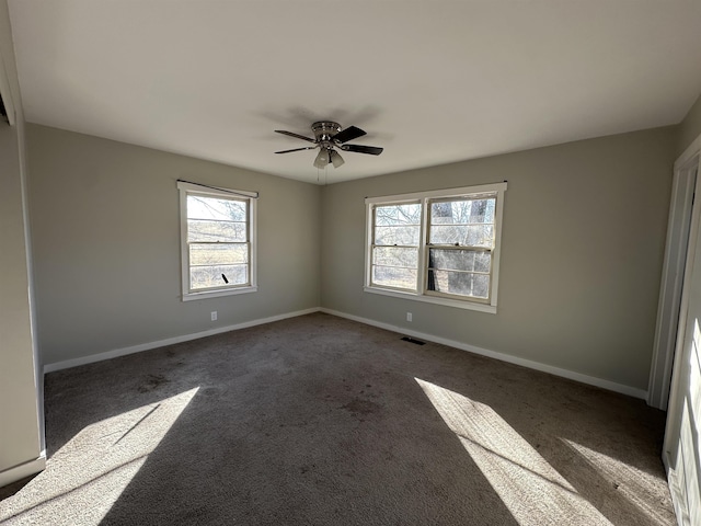 carpeted spare room featuring ceiling fan