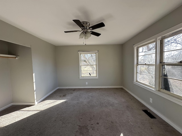 unfurnished room with ceiling fan and carpet