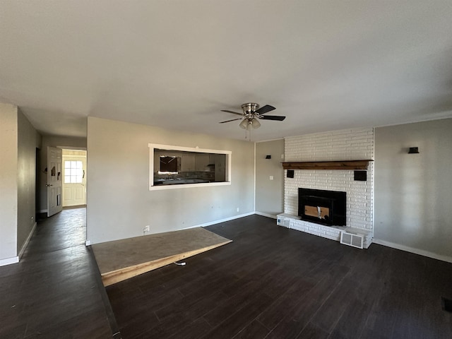 unfurnished living room featuring a fireplace, dark hardwood / wood-style floors, and ceiling fan