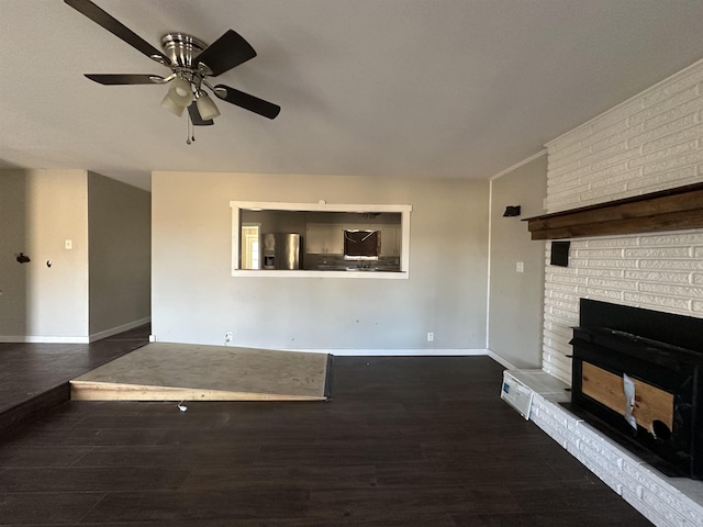 unfurnished living room featuring ceiling fan, dark hardwood / wood-style flooring, and a brick fireplace