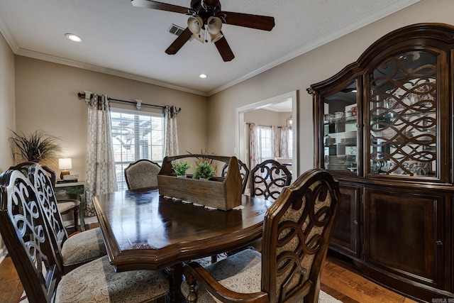 dining area with dark hardwood / wood-style flooring, crown molding, a wealth of natural light, and ceiling fan