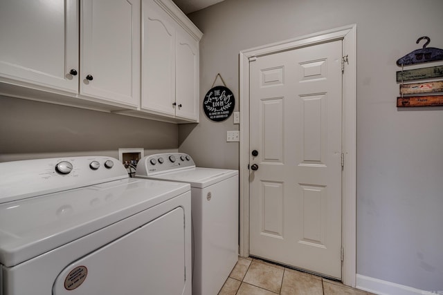 washroom featuring cabinets, separate washer and dryer, and light tile patterned floors