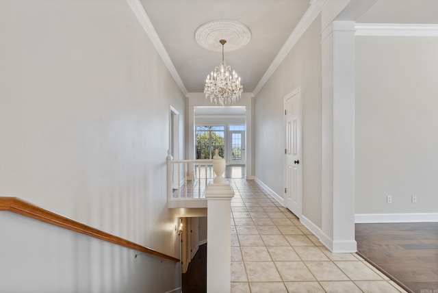 hallway featuring decorative columns, crown molding, light tile patterned floors, and a chandelier