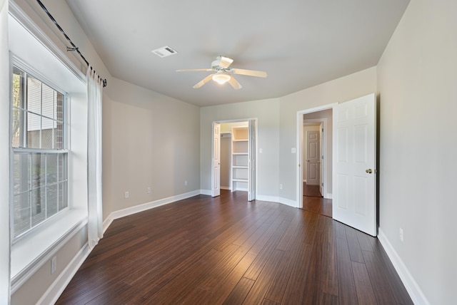 unfurnished room featuring dark wood-type flooring and ceiling fan